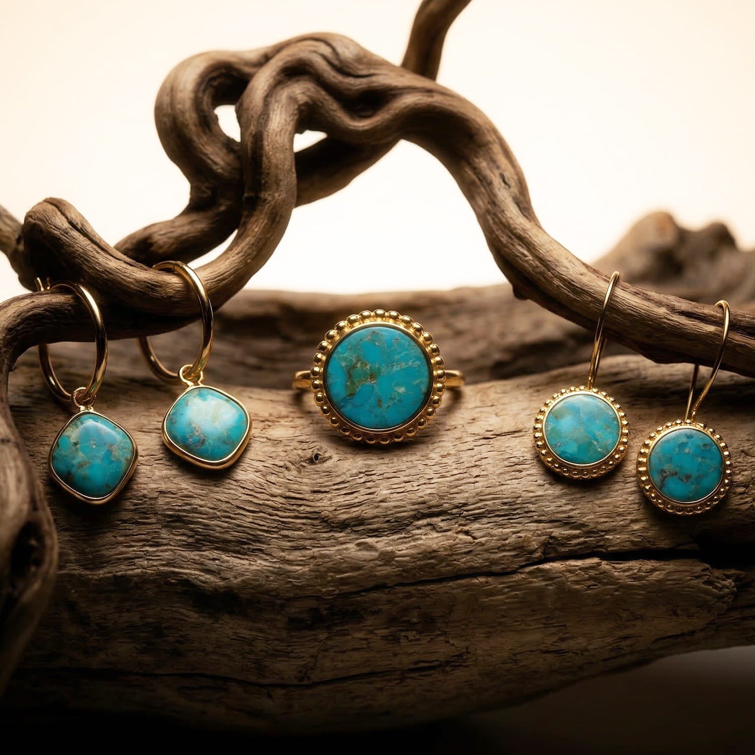 Assorted minimalist ethical jewelry pieces on light stone with soft greenery and linen background.