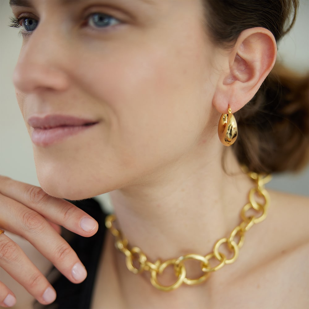 Whether you’re going full glam or keeping it simple, the largest Lola hoop earrings are here to make a statement.   Light enought to wear all day thanks to it's hollow center, these stunning gold hoops are moon shaped with a shiny soft finish.