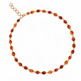 A gold chain necklace featuring oval amber-orange beads, arranged in a circle on a clean white background.