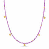A double-strand beaded necklace featuring faceted purple beads and small gold-toned textured disc charms, displayed on a clean white background.