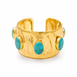 A wide gold cuff bracelet featuring five oval turquoise stone accents set in gold bezels, photographed on a clean white background.