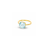 A gold ring with a cushion-cut light blue faceted gemstone, shown on a plain white background.