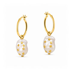 A pair of gold hoop earrings with irregular white baroque pearl drops, each accented with small gold studs, shown on a plain white background.