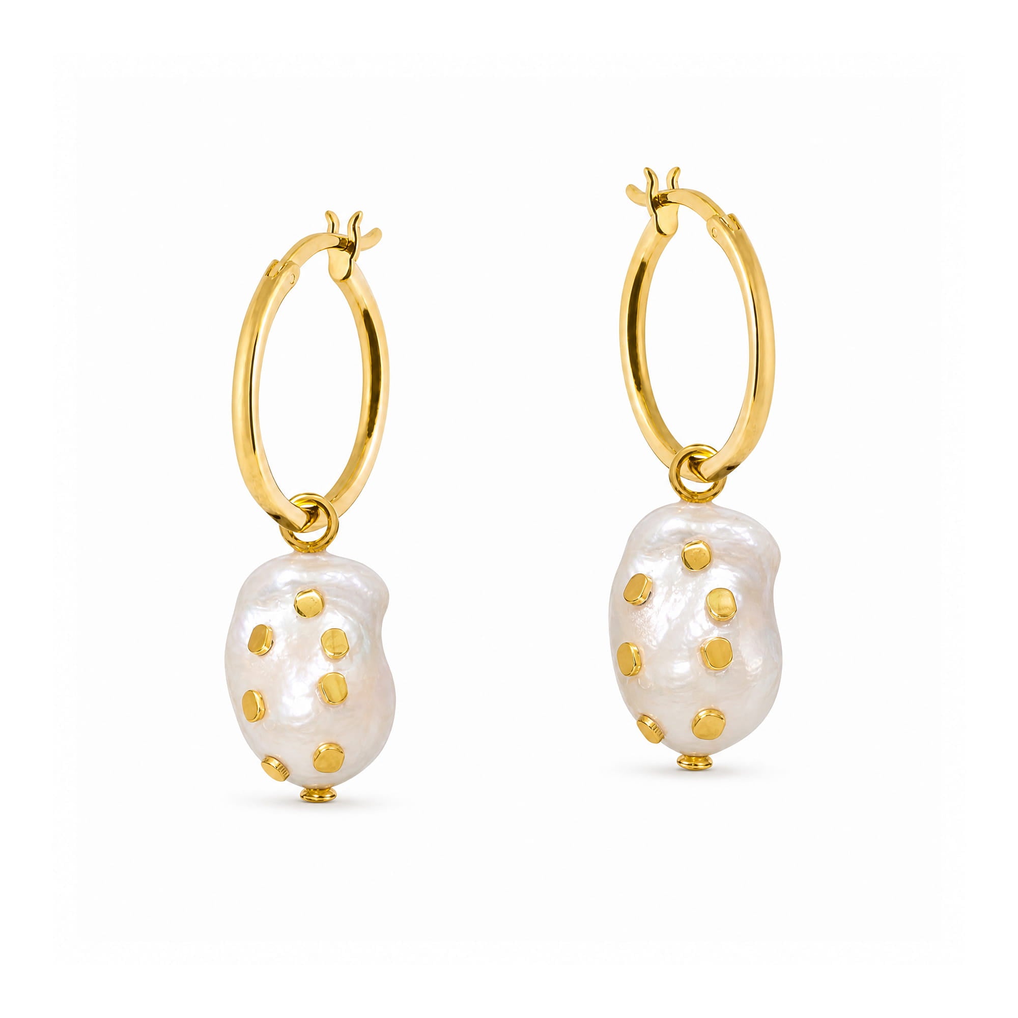 A pair of gold hoop earrings with irregular white baroque pearl drops, each accented with small gold studs, shown on a plain white background.