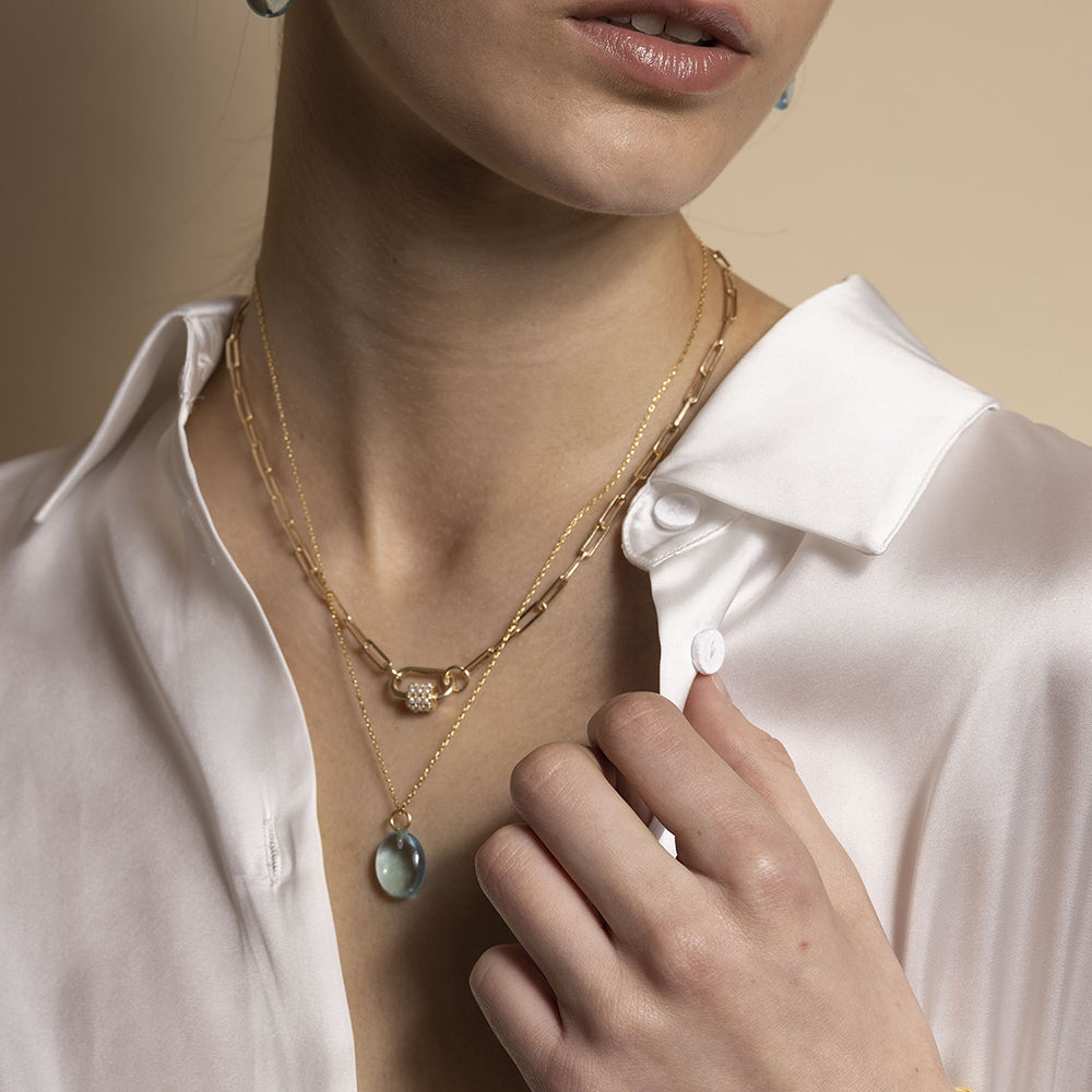 The Daphne Gold Necklace features dainty small white vintage pearls coating the carabiner lock. Entirely handmade with sustainable materials, this necklace is easily work day to night.