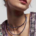 Handmade using sustainable materials, the Eva Lapis Lazuli Reversible Necklace with gold discs radiates shades of blue and gold from its vintage gemstones. Reverse the necklace for a smooth gold look or embossed texture on the charms.