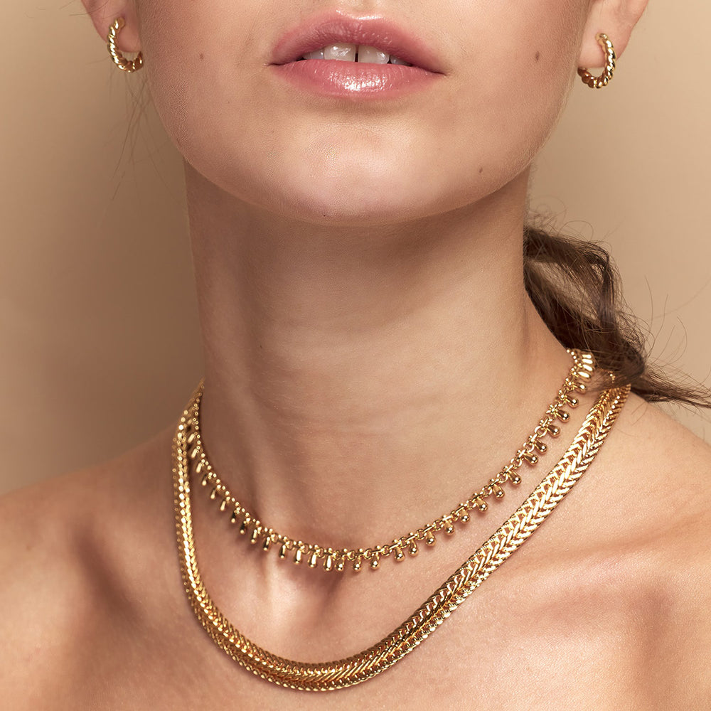The Katia Gold Chain Necklace with Teardrop Tassels is a gorgeously fluid necklace that boasts high-polished recycled gold. This sustainable jewellery piece is worn high up on the nneck but can also be adjusted to a longer length for those wanting to layer chains.