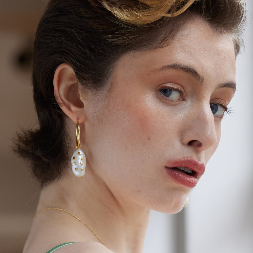 Meet the Venus Gold Hoop Earrings With large Keshi Pearl And Barnacles. Adorned with vintage keshi pearls and gold barnacles, this sustainable earring is a unique jewellery piece.&nbsp;